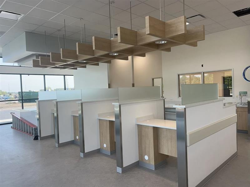 Phase 14 — Teller line: millwork cubicles with wood detail and glass privacy screens under a wood-slat feature ceiling