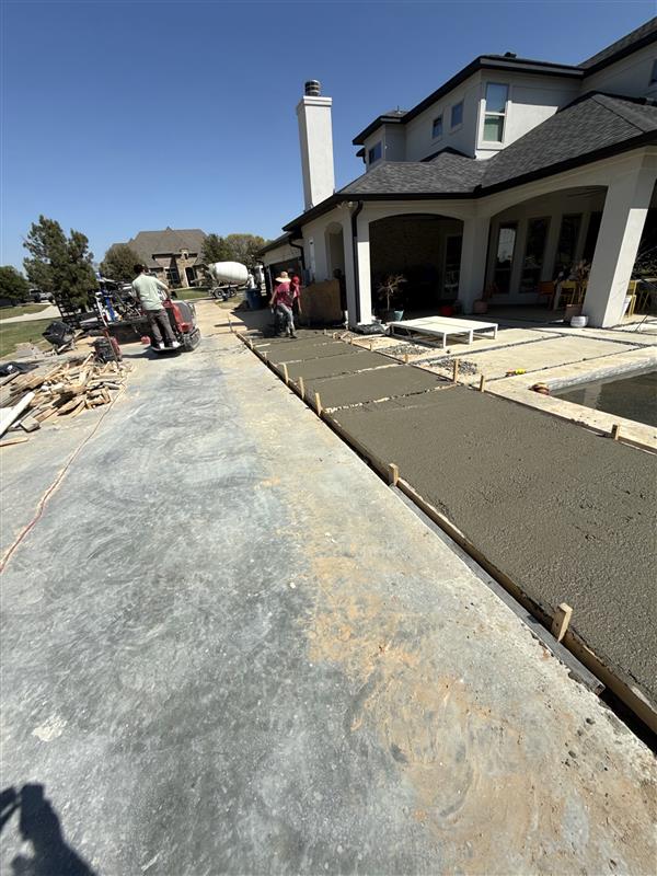 Phase 3 — Concrete pour underway with mixer truck, screeding fresh slabs