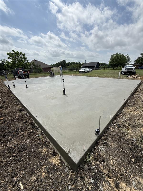 Phase 1 — Foundation: finished slab with anchor bolts set, ready for framing