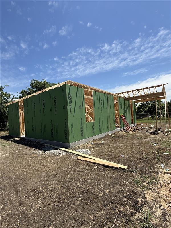 Phase 3 — Exterior walls up and roof framing beginning to take shape