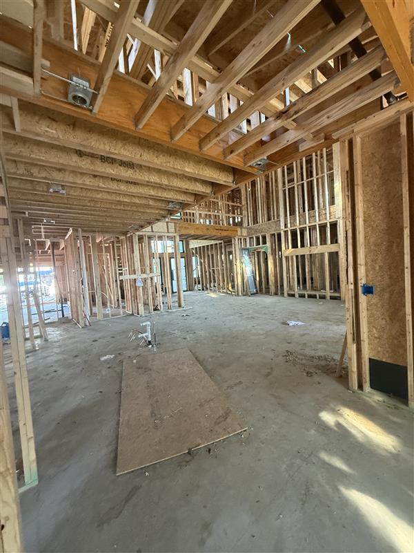 Phase 4 — Interior wood framing underway with floor joists set overhead