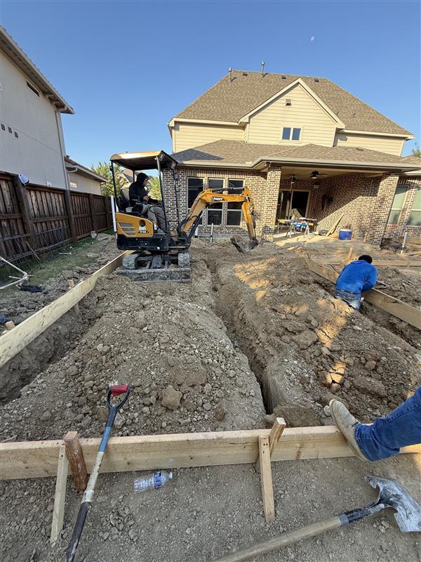 Phase 1 — Trench excavation behind the existing home with mini-excavator