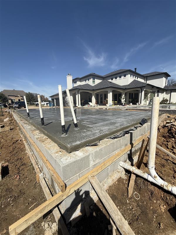 Phase 3 — Slab poured and finished with plumbing stub-ups set