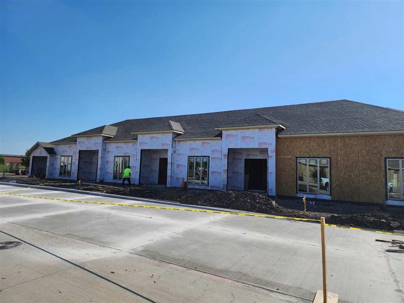 Long elevation dried-in: DRYline weather barrier, shingled roof and framed openings