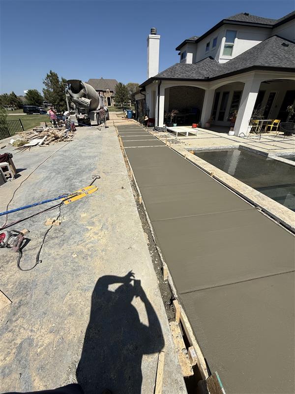 Phase 4 — Finished walkway pour running the length of the pool deck