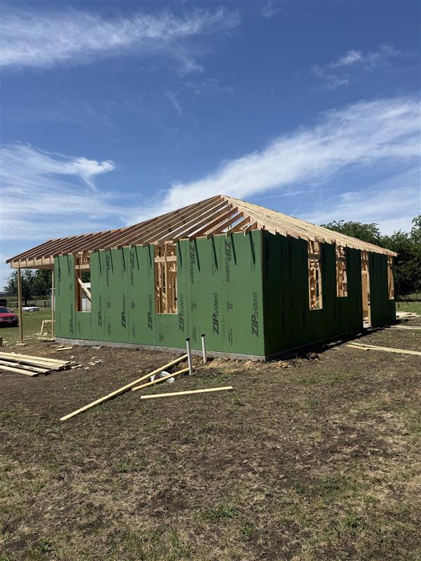 Phase 7 — Rear elevation sheathed with roof structure complete