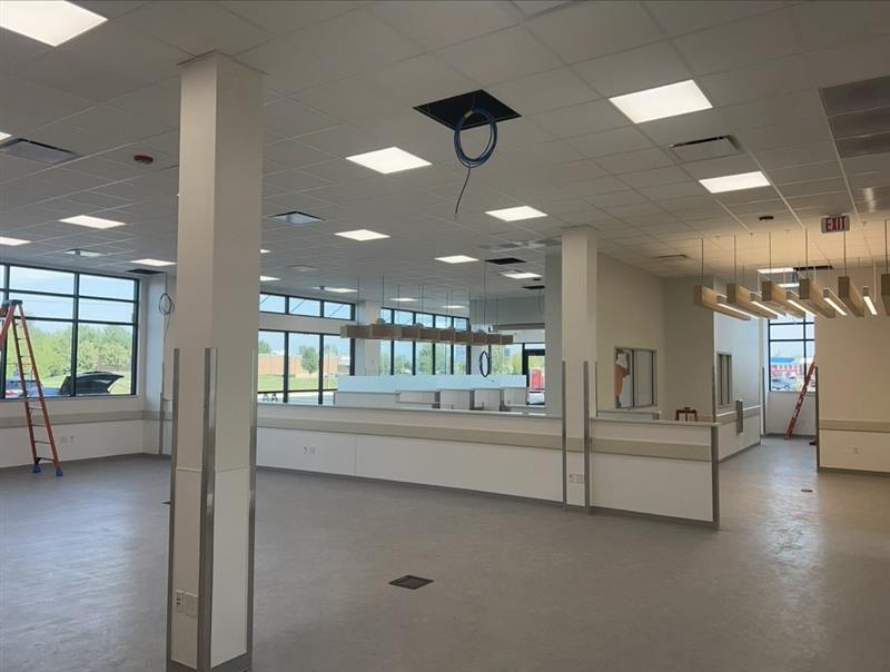 Phase 11 — Interior finish-out: ACT ceiling grid, LED lighting and wood-accent soffits over the transaction area