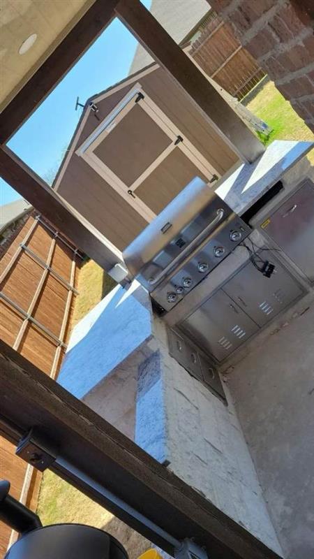 Phase 8 — Covered outdoor kitchen built out with stainless grill and cabinetry