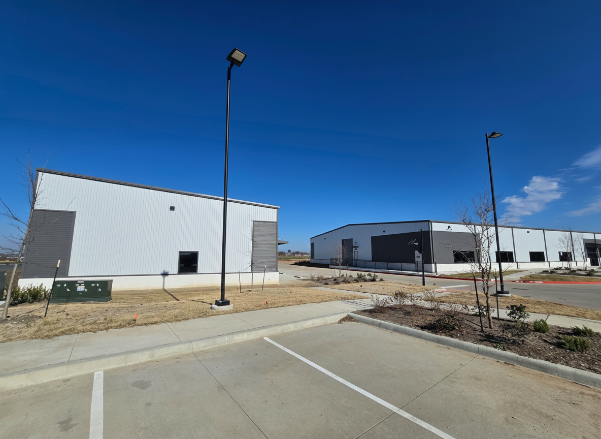 Wide exterior view: completed metal buildings with parking and site work